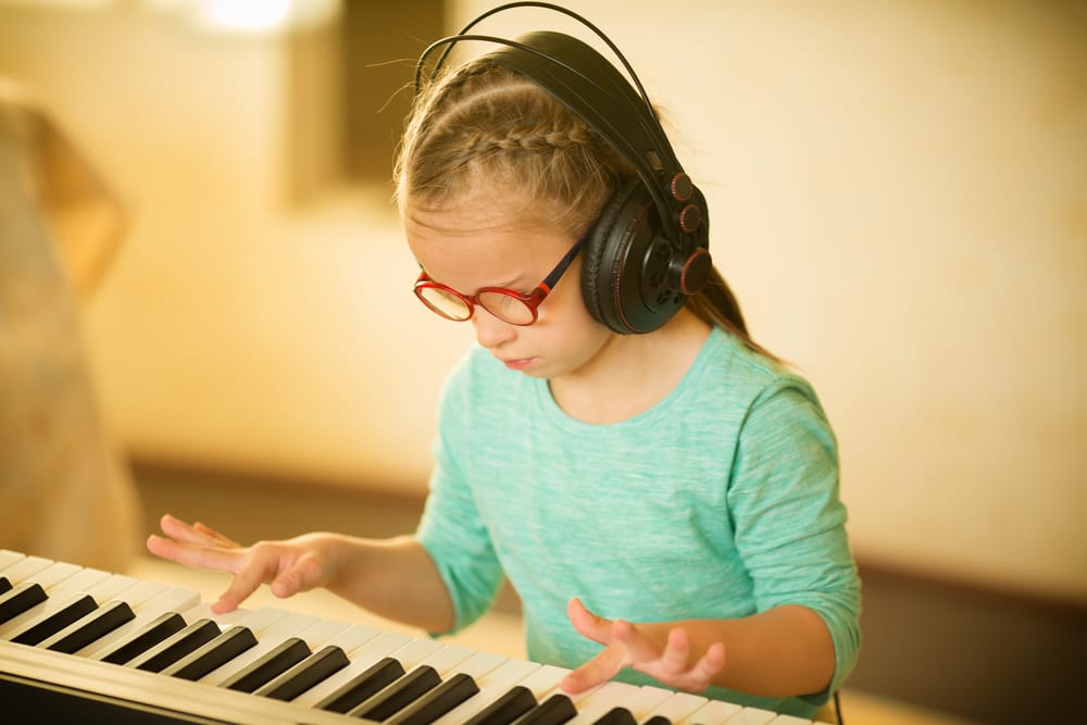 Criança com autismo praticando musicoterapia.