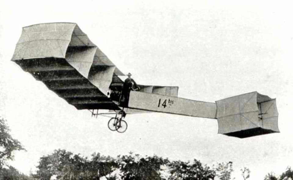 Protótipo de avião de Santos Dumont em um campo aberto.