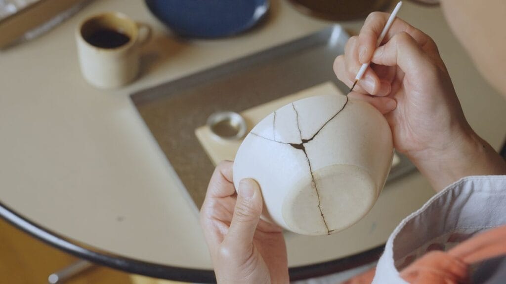 woman repairing broken pottery kintsugi royalty free image 1680030784